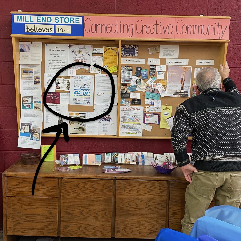 Man is looking at a sign on a community message board that says "Connecting Creative Community"