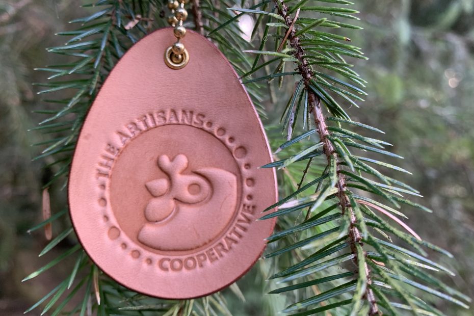 Leather Ornament Hanging from Tree with Artisans Cooperative Logo