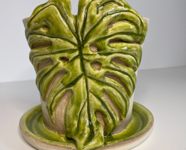 Hand thrown ceramic plant pot with a green monstera leaf motif for house plant enthusiasts