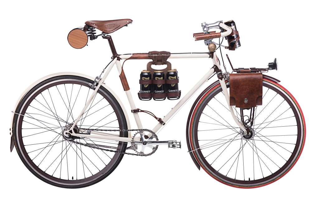 Cream colored bicycle with dark brown leather bicycle accessories by Walnut Studiolo