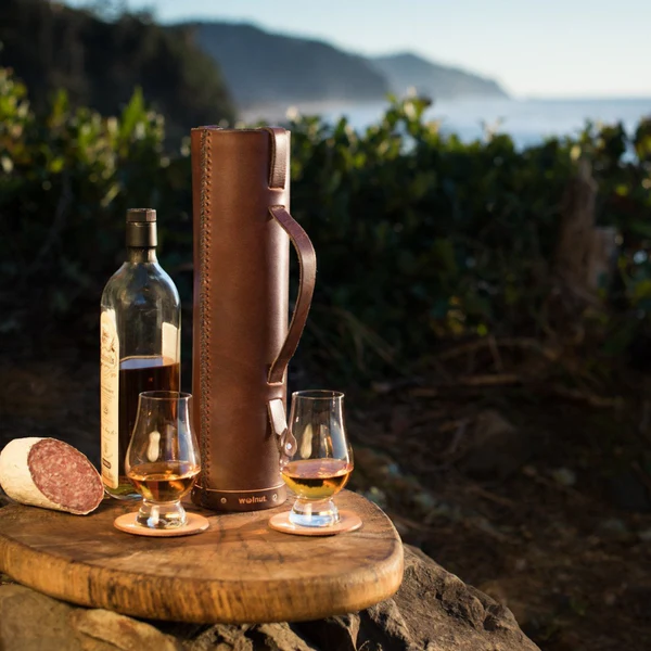 Leather wine bottle case on a cheese board on the Oregon Coast a romantic picnic for anniversary gifts
