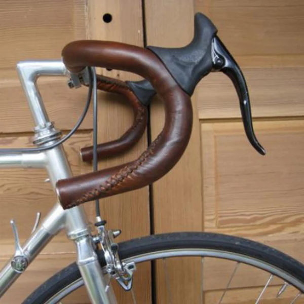 A picture of handmade, sew-on, leather bicycle handlebar wraps. 