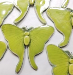 A photo of several sculpted luna moths. 