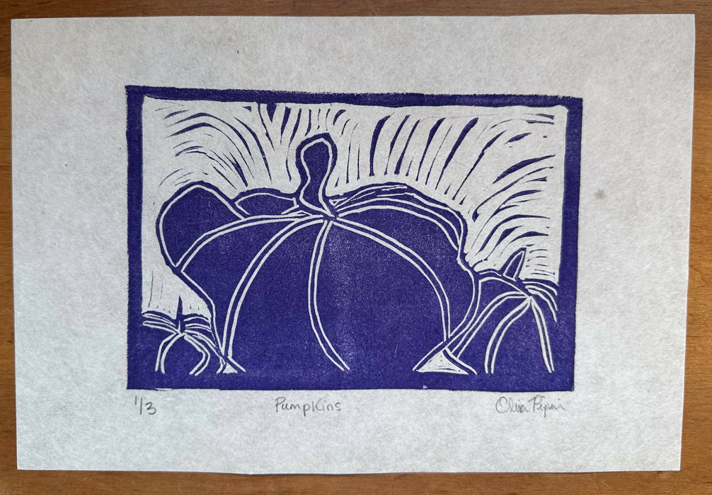 A handcarved block print of three pumpkins. The image shows blue ink on white paper. The pumpkins are particularly imperfect. There is lots of movement in the piece. The lines where the tool carved show, bringing a human touch to this lovely piece of art.