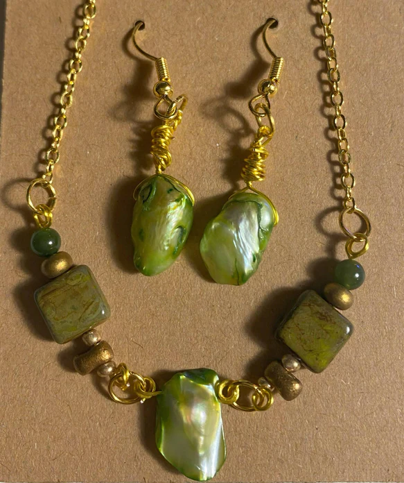 A matching necklace and earring set with olive green shiny stones and aged brass chains and hooks