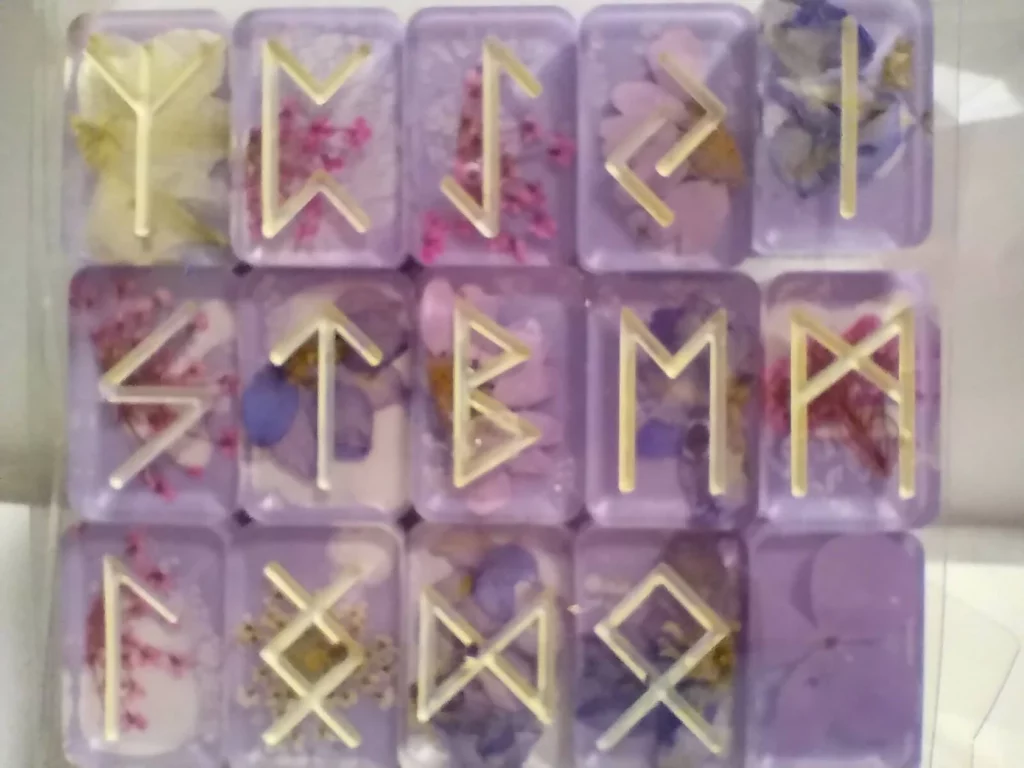 Handmade resin rune tile set. The resin is pastel purple and has flowers in it