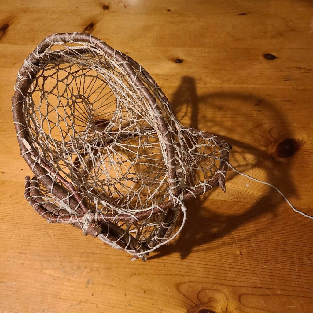 A hand-knotted fisherman's cornucopia dream catcher, a 3D sculpture piece made of natural hemp twine and foraged wood sticks