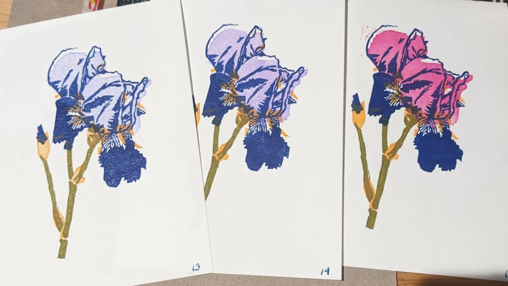 Handmade prints of an Iris in 3 colors, blue, purple and red on high quality paper