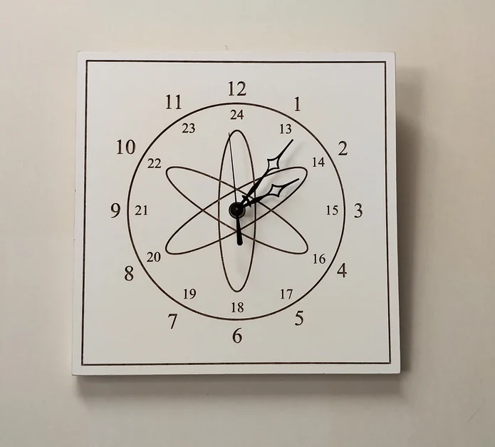 A white square wall clock on a white wall. The numbers are CNC cut from the wood and an atom symbol sits at the center.