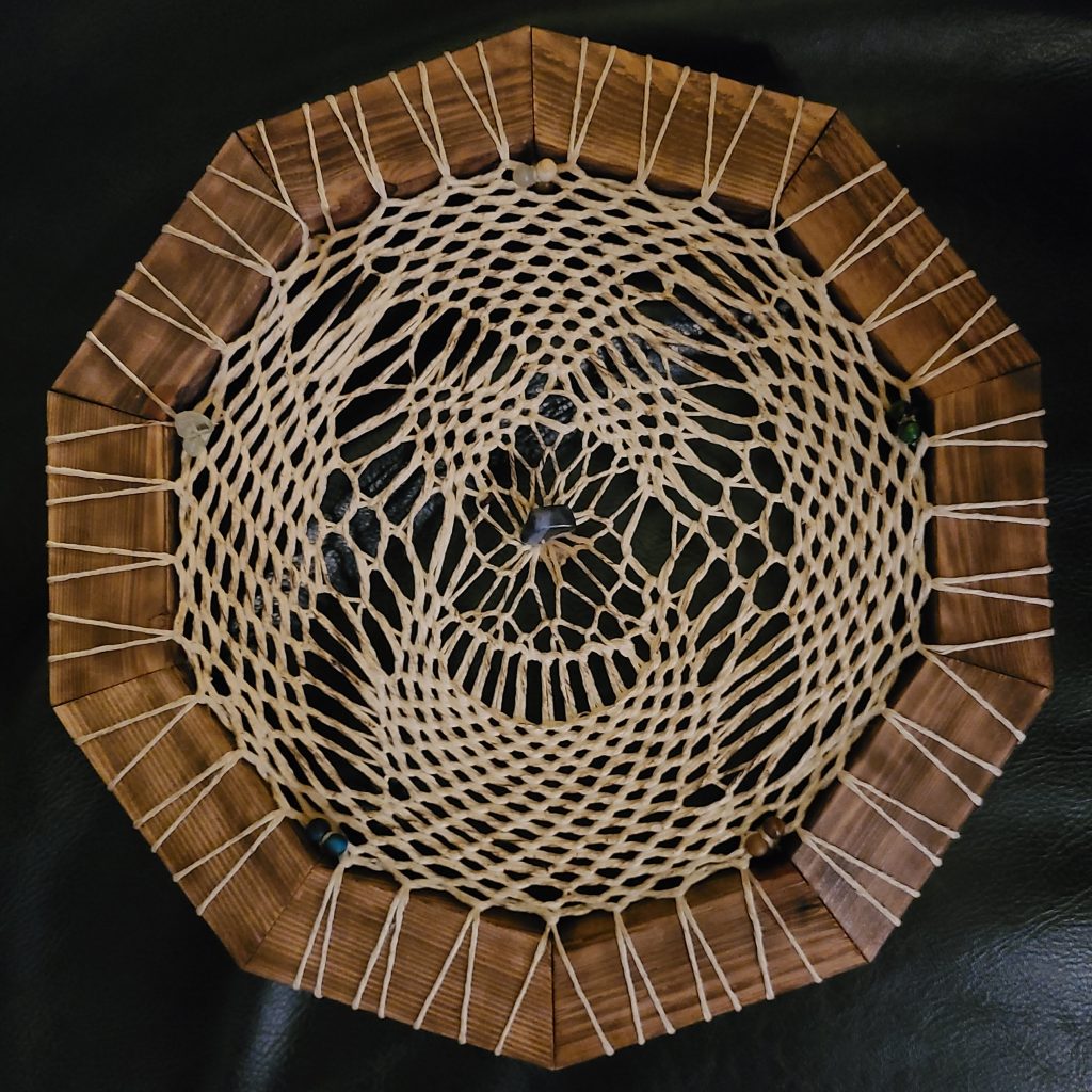 Woven sculpture dream catcher by Brent Joly. Hexagonal cedar stained frame with hemp weaving resembling an owl.