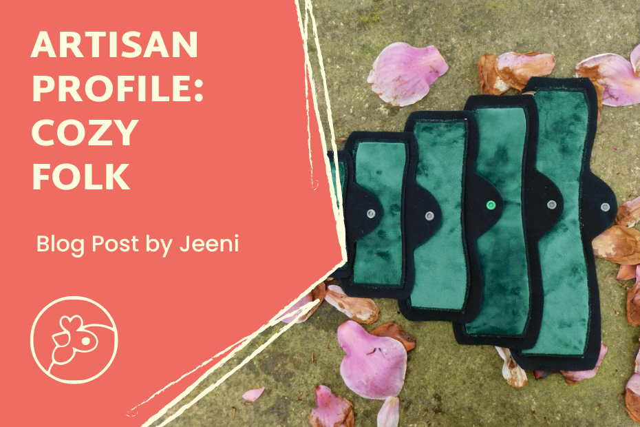 On the left it says "Artisan Profile: Cozy Folk" with "blog post by Jeeni" underneath and the Artisans Coop chicken logo below that. To the right is a photo of 4 menstrual pads aligned small to large (L to R) on the ground with rose petals around them.