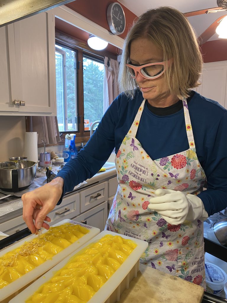 Sheri Veley of Blue Poppy Bath and Body making a vat of lemongrass soap in her kitchen wearing goggles and gloves for safety