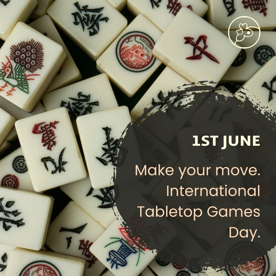 Mahjong tiles piled on each other in a scattered way with a dark circle and white text that reads: 1st June Make Your Move. International Tabletop Games Day.